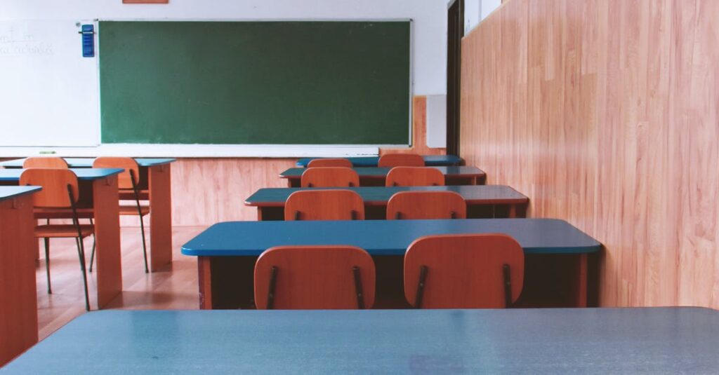 A tranquil empty classroom with wooden furniture and a green chalkboard, perfect for educational themes.