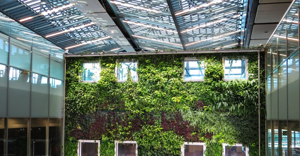 Contemporary indoor space featuring a lush vertical garden and a sleek glass roof, blending nature with architecture.
